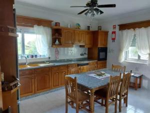 a kitchen with wooden cabinets and a table with chairs at Casa da Cavada - 6 quartos-rooms in Caminha