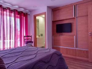 a bedroom with a bed and a flat screen tv at Casa da Cavada - 6 quartos-rooms in Caminha