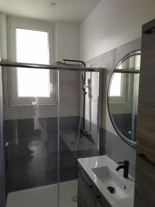 een badkamer met een wastafel en een spiegel bij T3 COSY REFAIT A NEUF PROCHE GARE in Perpignan