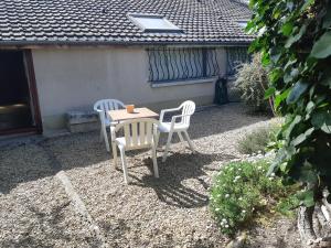 une table et des chaises assises sur une terrasse dans l'établissement Maison à Troyes, à Troyes