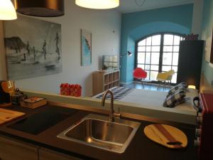 a kitchen with a sink and a room with a window at meraviglia in Savona