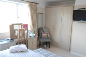 a bedroom with a bed and a dresser and a mirror at Hysett House in Midhurst