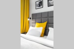 łóżko z żółtymi i białymi poduszkami w obiekcie HOUSEHOST Apartment: Miodowa 42/8a Street w Krakowie