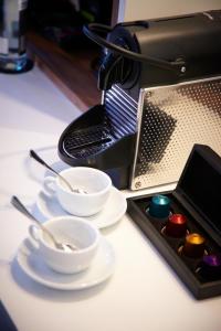 a table with plates and bowls and a coffee machine at Malmaison London in London