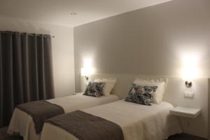 ein Hotelzimmer mit 2 Betten und 2 Lampen in der Unterkunft Hotel Beatriz in Serpa