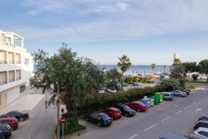 a row of cars parked in a parking lot next to the ocean at Apartamento Murillo in Barbate