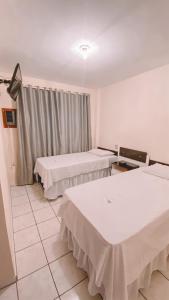 une chambre à l'hôpital avec trois lits et une fenêtre dans l'établissement Nacional Park Hotel Lages, à Lages
