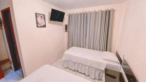 a small room with a bed and a window at Nacional Park Hotel Lages in Lages
