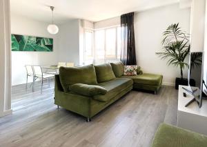 a living room with a green couch and a table at Luxury Cercas Bajas Vitoria in Vitoria-Gasteiz