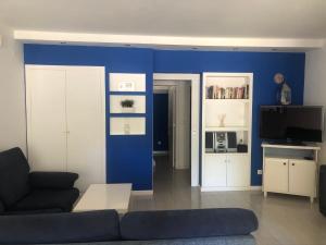 uma sala de estar com um sofá e uma parede azul em Troia em Tróia