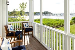 a porch with two chairs and a view of the water at Inn at Haven Harbour in Rock Hall