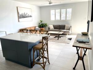 a kitchen and living room with a large island at Rockpool 2 Sawtell Beach - Just steps to Restaurants and 2 min Stroll to Beach! in Sawtell