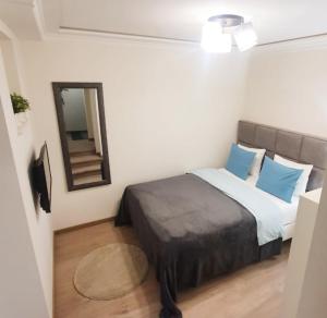 1 dormitorio con cama con almohadas azules y espejo en Apartment My Home, en Belgrado