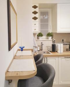 Una cocina con una mesa de madera y dos sillas. en Apartment My Home, en Belgrado