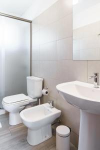 ein weißes Bad mit einem WC und einem Waschbecken in der Unterkunft Taurinas in Colonia del Sacramento
