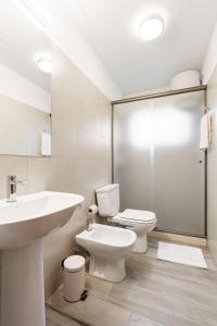 a white bathroom with a sink and a toilet at Taurinas in Colonia del Sacramento