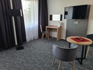 シュテンダールにあるHanse-Hotel Stendalのテーブル、椅子、デスクが備わる客室です。