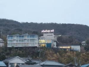 ein Gebäude mit einem Schild auf dem Hügel in der Unterkunft HOTEL HIMALAYA SEA in Ito