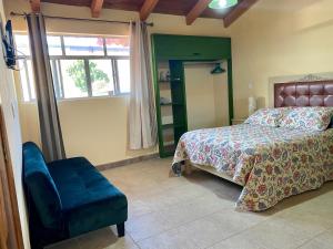 a bedroom with a bed and a chair and a window at Habitación agradable in Comitán