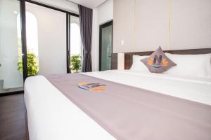 a bedroom with a large white bed with a white bedspread at Nile Hotel in Tuy Hoa