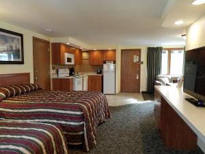 een hotelkamer met een bed en een keuken bij Black Hawk Motel & Suites in Wisconsin Dells