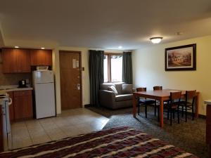 a living room with a kitchen and a dining room table at Black Hawk Motel & Suites in Wisconsin Dells