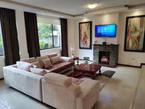 sala de estar con sofá y chimenea en Hospedaje en Quito Norte, Apartamento & Suite independientes, en Quito