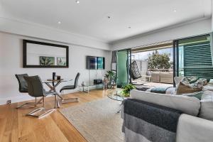 a living room with a couch and chairs and a table at Ultimate outdoor-living Urban Getaway! 1 Carpark in Auckland