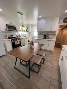 a kitchen with white cabinets and a wooden table at Private Room in LA with free WIFI and TV with Shared Kitchen in Los Angeles