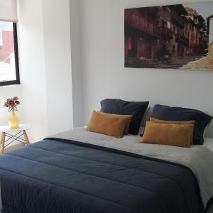 a bedroom with a bed with blue sheets and pillows at HERMOSO Apartamento Ibague 301 F1 in Ibagué
