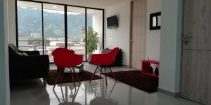 - un salon avec trois chaises rouges devant une fenêtre dans l'établissement HERMOSO Apartamento Ibague 301 F1, à Ibagué