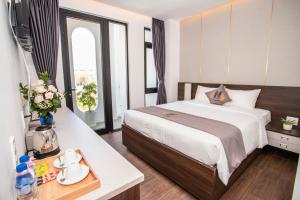 a hotel room with a large bed and a table at Nile Hotel in Tuy Hoa