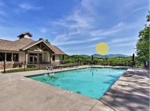 a swimming pool in front of a house at Gorgeous Cades Cove Condo with Community Pool in Townsend