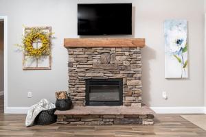 a living room with a stone fireplace with a flat screen tv at Gorgeous Cades Cove Condo with Community Pool in Townsend