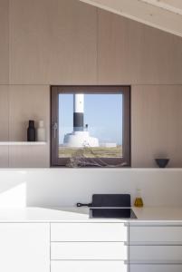 a kitchen with a window with a view of a lighthouse at Radar by Bloom Stays in Littlestone-on-Sea