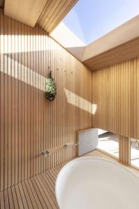 a bathroom with a tub and wooden walls at Radar by Bloom Stays in Littlestone-on-Sea