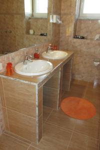 a bathroom with two sinks and a mirror at Willmersdorfer Hof in Cottbus