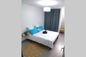 - une chambre avec un lit doté d'oreillers bleus et d'un tapis dans l'établissement Jadessie ( Centre ville /Downtown ), à Pointe-à-Pitre