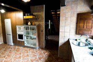 a kitchen with a refrigerator and a sink in it at Casa Rural Aquilamas in La Bastida