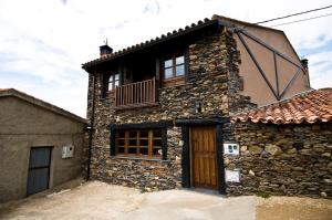 una casa de piedra con un balcón en un lateral. en Casa Rural Aquilamas, en La Bastida
