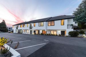 a large white building with a parking lot at Amity Serviced Apartments in Queenstown