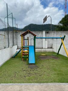 a playground with a slide and a swing at Apartamento Aconchegante Sun Way in Ubatuba