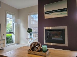 a living room with a fireplace and a table at Redwood Delight in Cowes