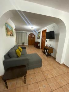 a living room with a couch and a flat screen tv at Pura Vida! Ciudad Hidalgo in Ciudad Hidalgo
