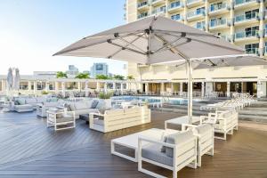 a patio with white furniture and an umbrella at Ala Moana Hotel - Resort Fee Included in Honolulu