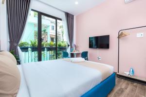een slaapkamer met een groot bed en een balkon bij Cozrum Homes Greena House in Ho Chi Minh-stad