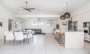 uma cozinha e sala de estar com mesa e cadeiras em Noosaville Hideaway em Noosaville