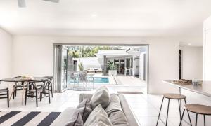a living room and dining room with a couch and a table at Noosaville Hideaway in Noosaville