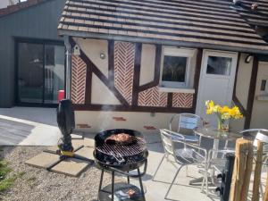 a backyard with a grill and a table and a house at Gîte Évasion idyllique in Faverolles-sur-Cher