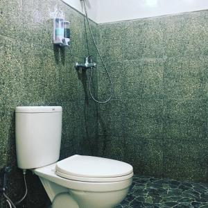 a bathroom with a toilet and a shower at Tommy Homestay in Plambi +29 photos